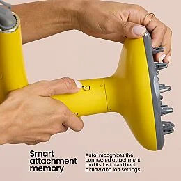 Hands attaching the diffuser accessory to the Drybar Buttercup Pro hair dryer.