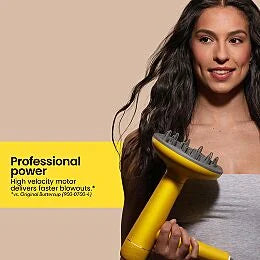 Person with long wavy hair holding the Drybar Buttercup Pro hair dryer with diffuser attachment.